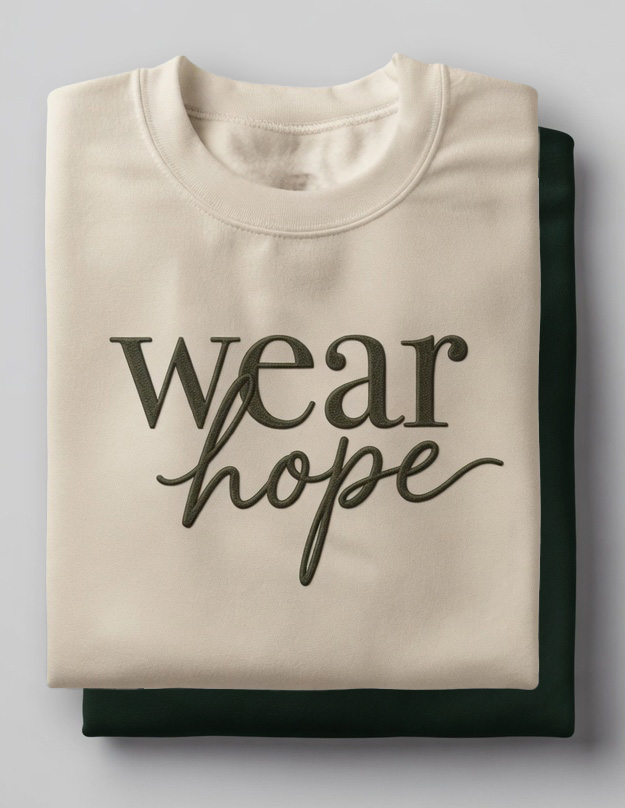 Two folded wear hope crewneck sweatshirts in forest green and cream with tonal embroidered script.